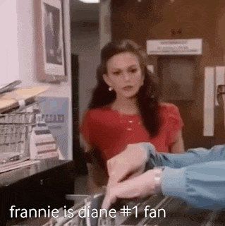 a woman in a red shirt is standing next to a man in a blue shirt and talking to him .