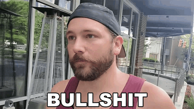 a man with a beard wearing a hat and a tank top says bullshit