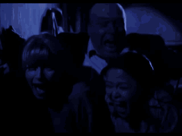a group of people with their mouths open in the dark