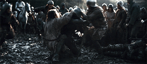a group of soldiers are fighting each other in a muddy field