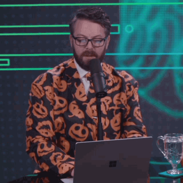 a man in a pumpkin suit is sitting in front of a microphone and says it is dope