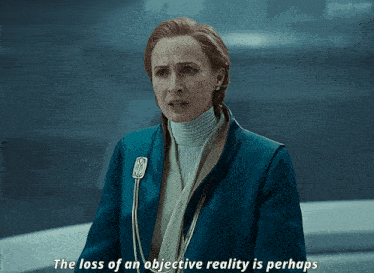 a woman in a blue jacket says the loss of an objective reality perhaps