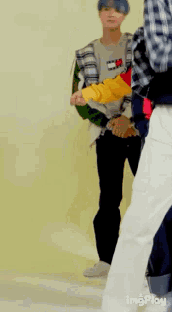 a man in a plaid shirt and a yellow jacket is dancing