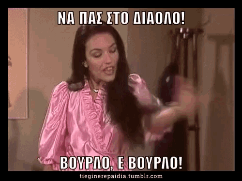 a woman in a pink shirt is standing in front of a sign that says na pas sto diaolo boypao e boypao