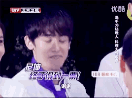 a man in a white shirt with a purple scarf around his neck is on a btv screen