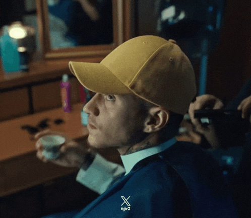 a man wearing a yellow hat and a blue suit has the letters 6jr2 on his shirt