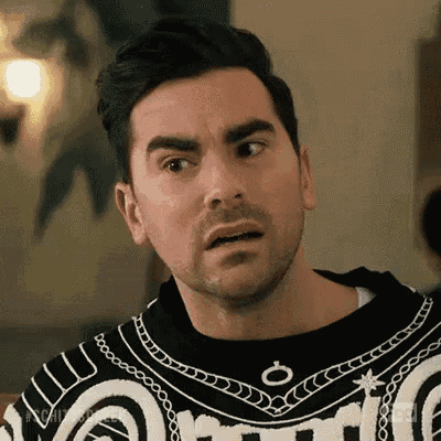 a man with a beard is wearing a black and white sweater .