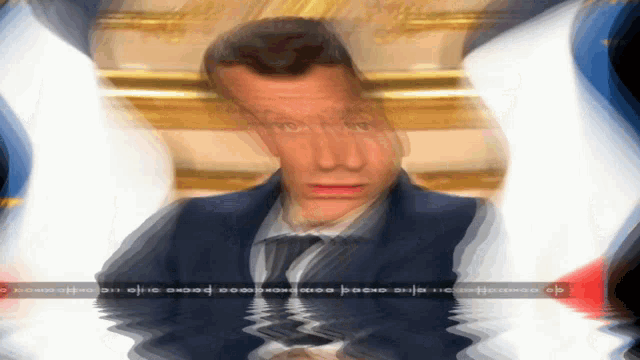 a blurry picture of a man in a suit and tie is surrounded by flags