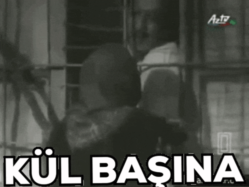 a black and white photo of a man behind bars with the words kul basina in white letters