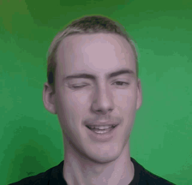 a close up of a man 's face against a green screen