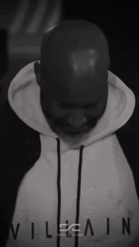 a black and white photo of a man wearing a white hoodie with the word villain on it