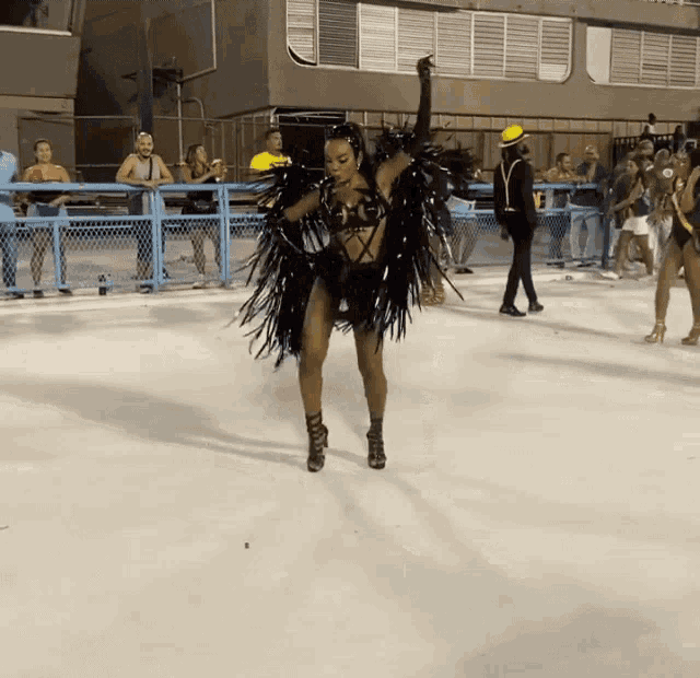 a woman in a black costume is dancing on a ice rink