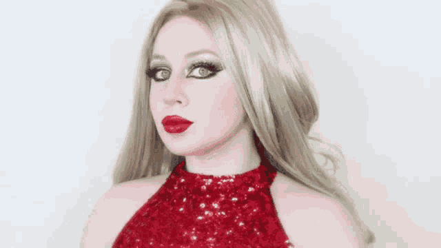 a woman is wearing a red dress and red lipstick .