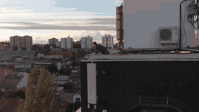 a man is standing on the roof of a building