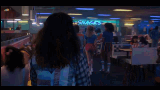 a woman with long hair and a plaid shirt is screaming in a diner