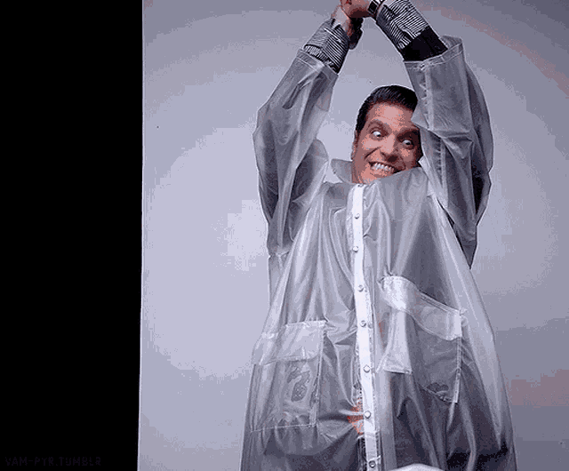 a man in a clear plastic raincoat is smiling