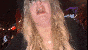 a woman with blonde hair and glasses is making a face