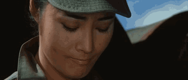 a close up of a woman 's face wearing a hat