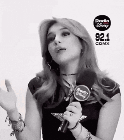 a woman is holding a microphone and talking into it .