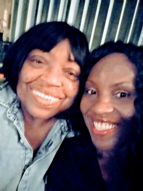 two women are posing for a photo and smiling for the camera