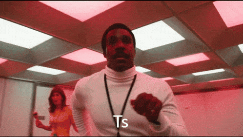 a man in a white turtleneck is dancing with the word ts written on his chest