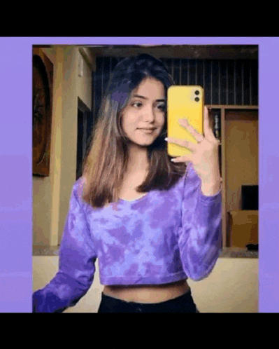 a girl is taking a selfie in a mirror with her phone .
