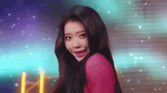 a woman in a pink shirt is looking at the camera and smiling .