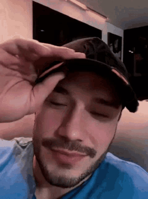 a man with a beard is wearing a baseball cap on his head