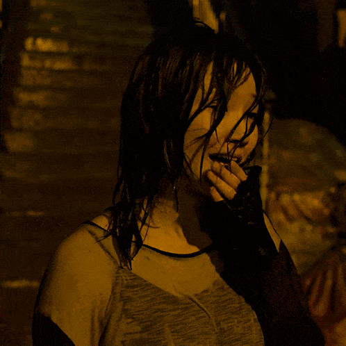 a woman with wet hair is wearing a black tank top