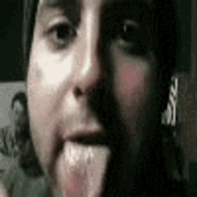 a close up of a person 's face with their tongue hanging out .