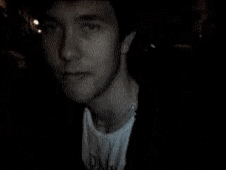 a close up of a man 's face with his eyes closed in a dark room .