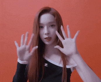 a woman with long red hair is wearing a black shirt with the letter e on the sleeve