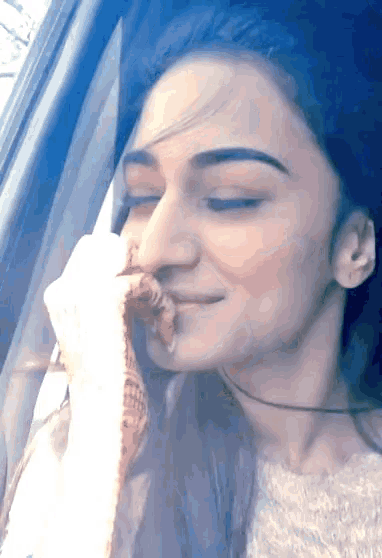 a woman in a car with her eyes closed and her hand on her face