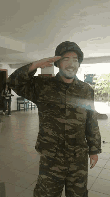 a man in a military uniform salutes while a woman stands behind him