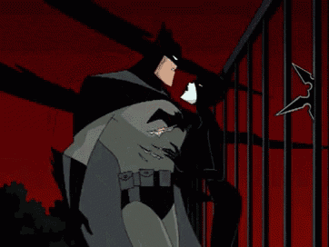 a cartoon of batman and catwoman standing next to each other in a cage .