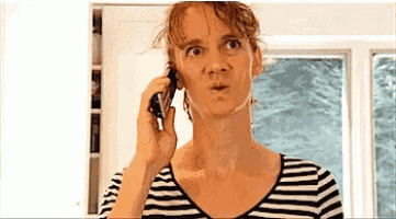 a woman wearing a striped shirt talking on a cell phone