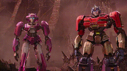 a couple of robots are standing next to each other in a forest .