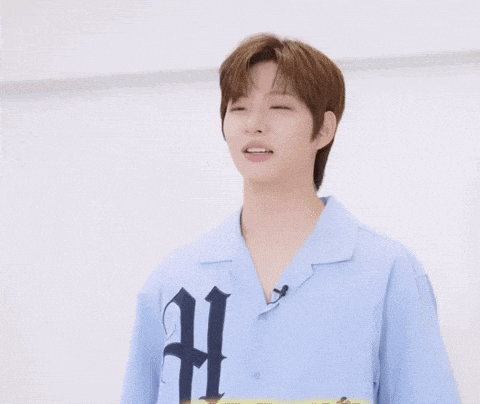 a young man wearing a blue shirt with the letter h on it gives a thumbs up