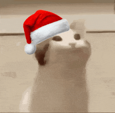 a white dog wearing a santa hat with its mouth open