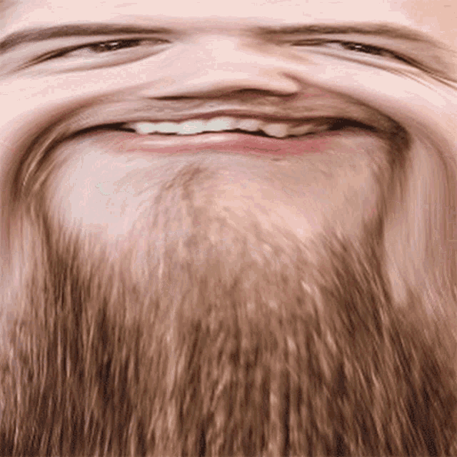 a man with a beard is smiling with his mouth wide open
