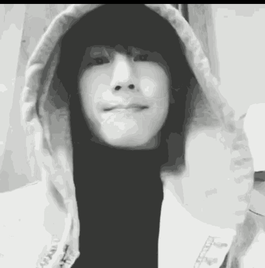 a black and white photo of a person wearing a hoodie and a black turtleneck .