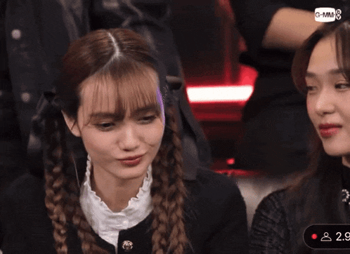two girls are sitting in front of a screen that says g-mm-8
