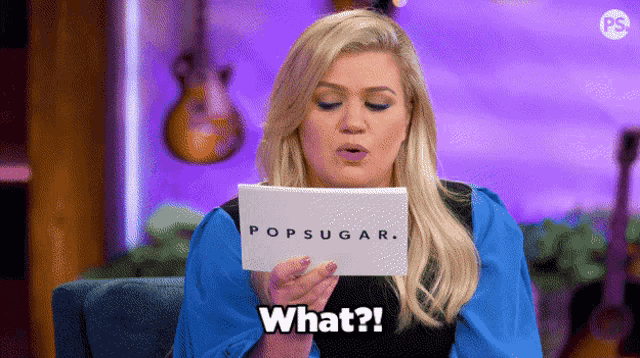a woman holding a piece of paper that says popsugar what
