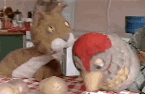 a stuffed animal is standing next to a stuffed animal on a table .