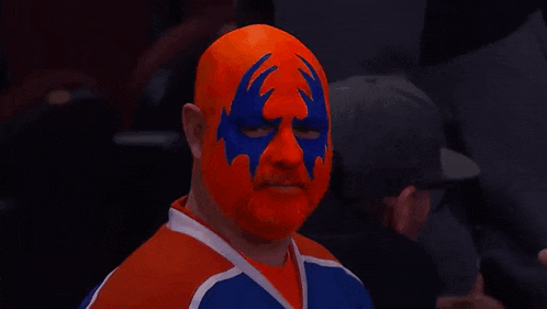 a man with a mask on his face is wearing an orange and blue jersey with the word sky on it .
