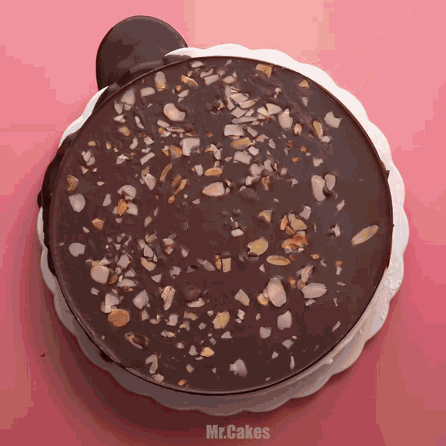 a chocolate cake with nuts on top and the words mr.cakes below