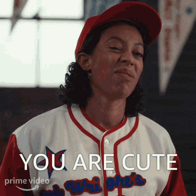 a woman wearing a baseball jersey that says you are cute on it