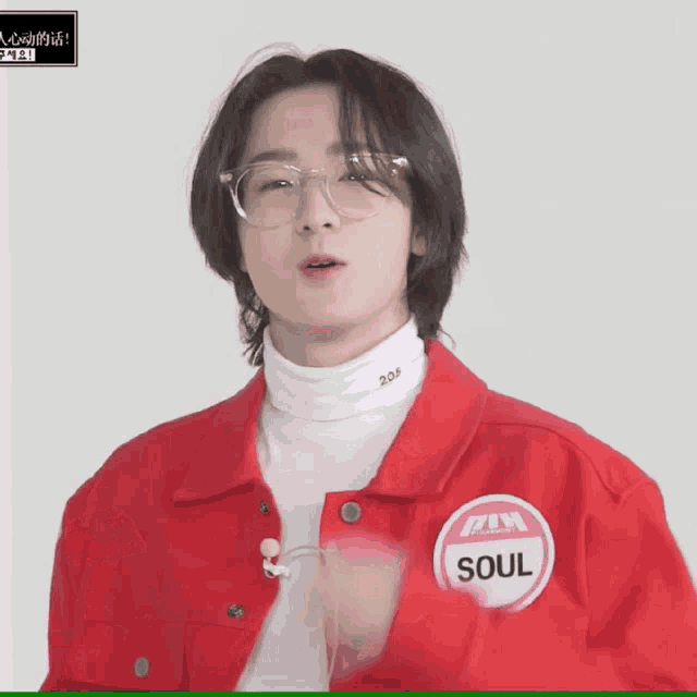 a young man wearing glasses and a red jacket has a sticker that says soul on it