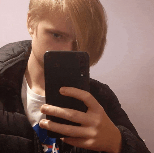 a young man is taking a selfie with a cellphone