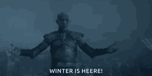 a man in armor is standing in front of a crowd of people and says `` winter is here '' .